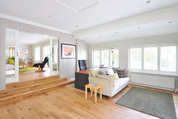 A cozy living room featuring wooden floors and white walls, creating a bright and inviting atmosphere.