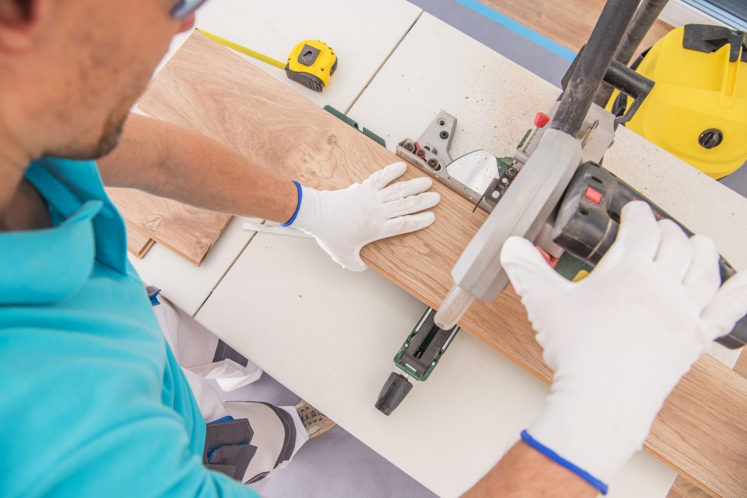 A man operates a circular saw, skillfully cutting through a piece of wood in a workshop setting.